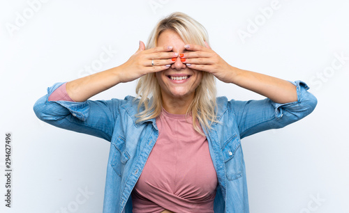 Young blonde woman over isolated white background covering eyes by hands