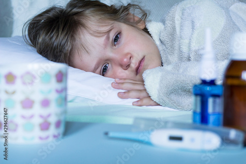 Exhausted, sick child with fever lying in bed. Healthcare and medical concept. Close up.