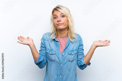 Young blonde woman over isolated white background making doubts gesture