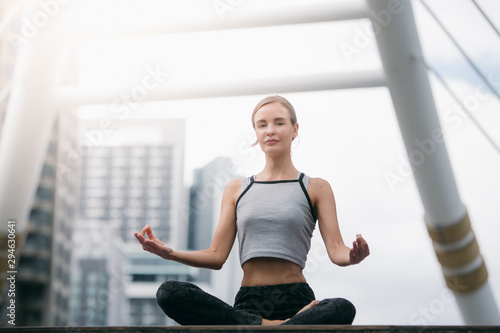 Caucasian woman wearing sportswear practicing yoga in the city