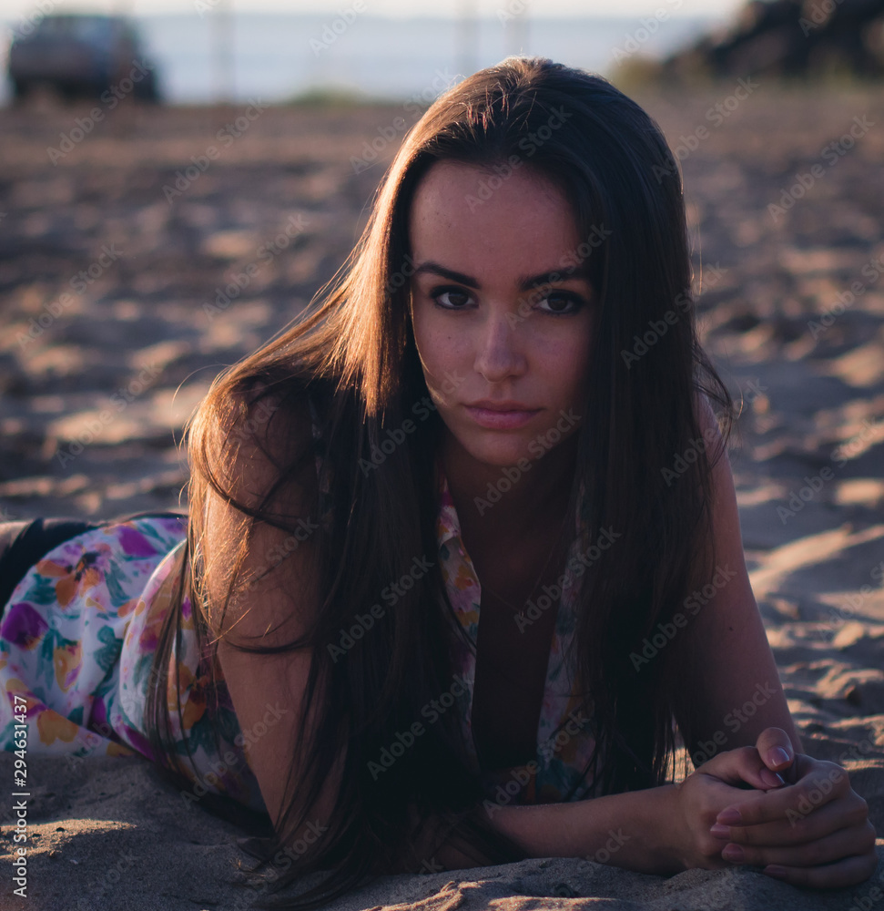 Fototapeta premium fashion outdoor photo of beautiful sexy woman with dark hair in light shirt relaxing at the beach.