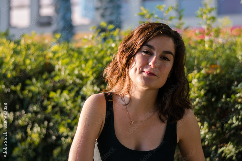 Portrait of a young woman in a park of a city Portrait of a young woman in a park of a city