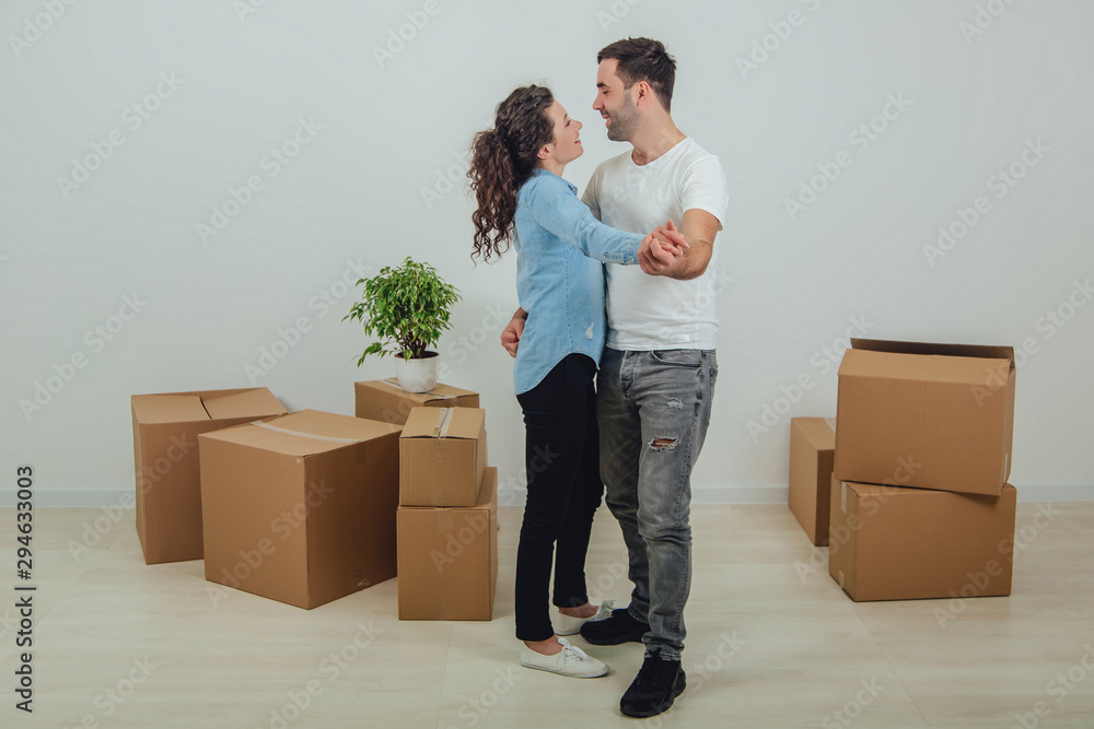Man and woman in new apartment, surrounded by carton boxes, dancing, being in the seventh heaven to change location. Man and woman in new apartment, surrounded by carton boxes, dancing, being in the seventh heaven to change location.