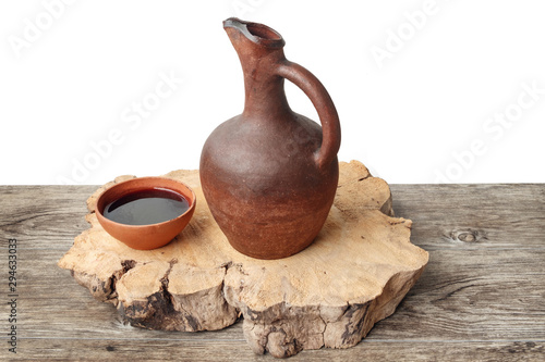 Wine jug and clay cup on the wooden table photo