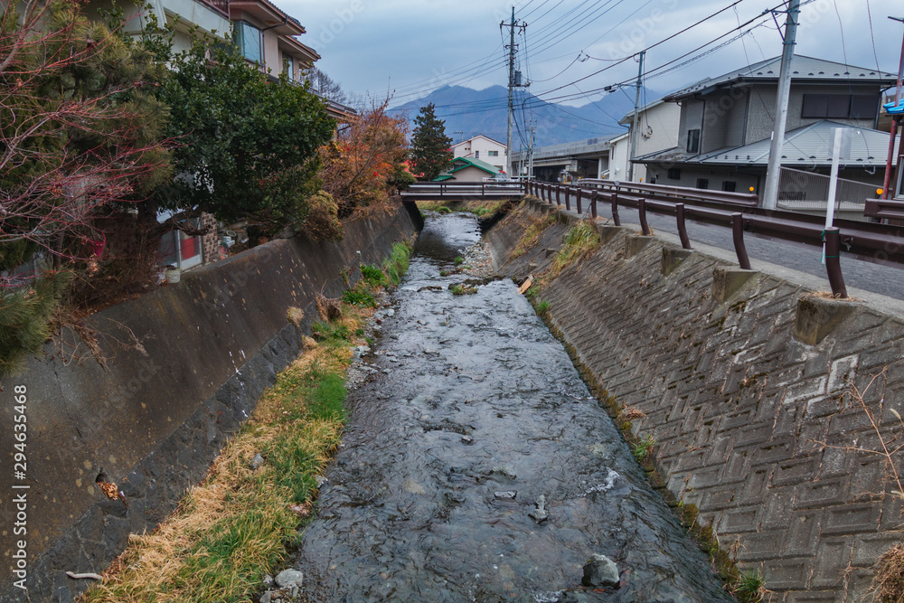 The canal beside local lanes between Shimoyoshida and Chureito Pagoda, Japan. The water in the canal is clear and clean.