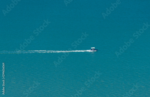 A speedboat sailing in the blue bay
