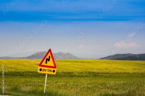 warning sign on road in grain fild