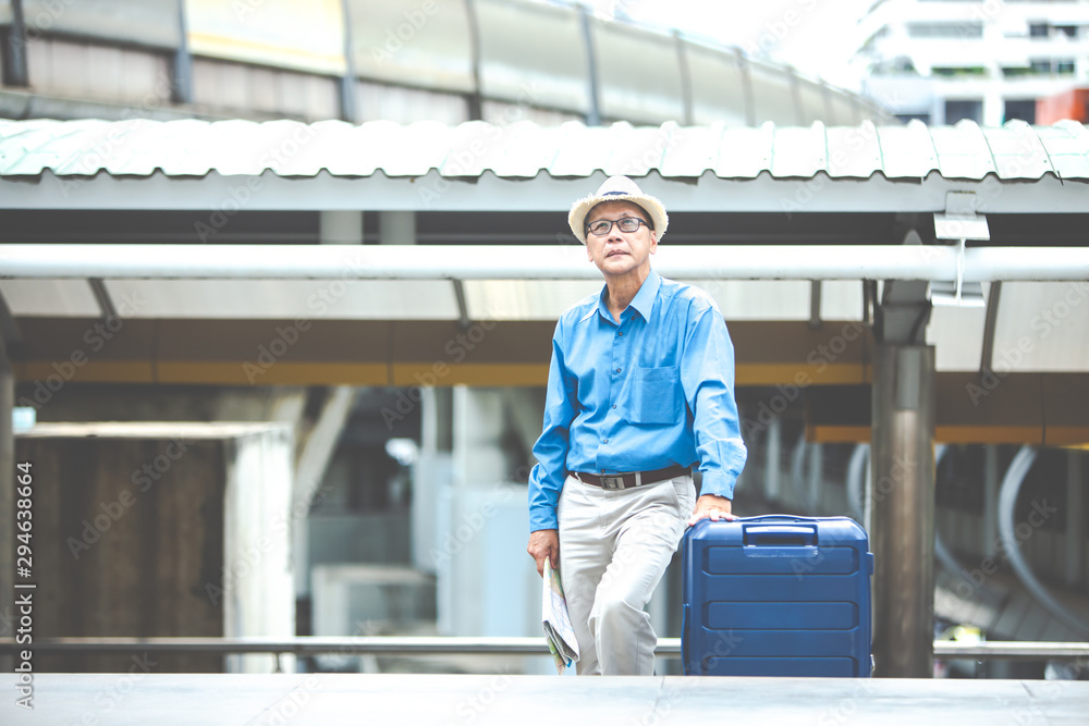 Fototapeta premium Portrait of happy senior mature man of travelers with luggage and map. Enjoying travel and happy tourism concept.