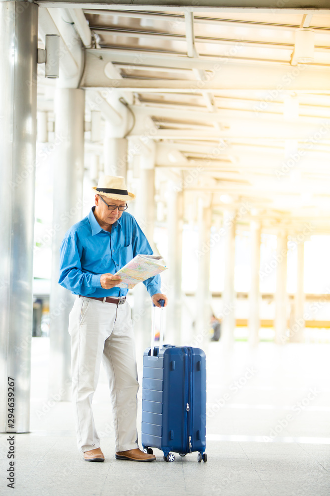 Senior man traveling with luggage checking city map and sightseeing. Senior man Travel and tourism concept. Senior man traveling with luggage checking city map and sightseeing. Senior man Travel and tourism concept.