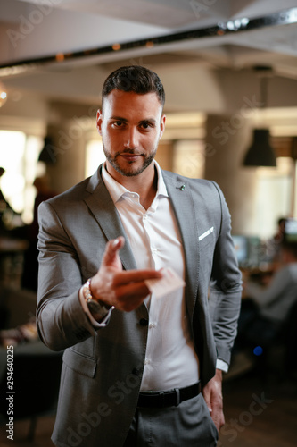 Handsome businessman giving visit card