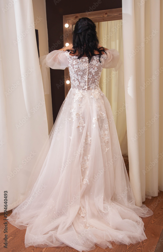 bride tries on wedding dress in wedding dress shop bride tries on wedding dress in wedding dress shop