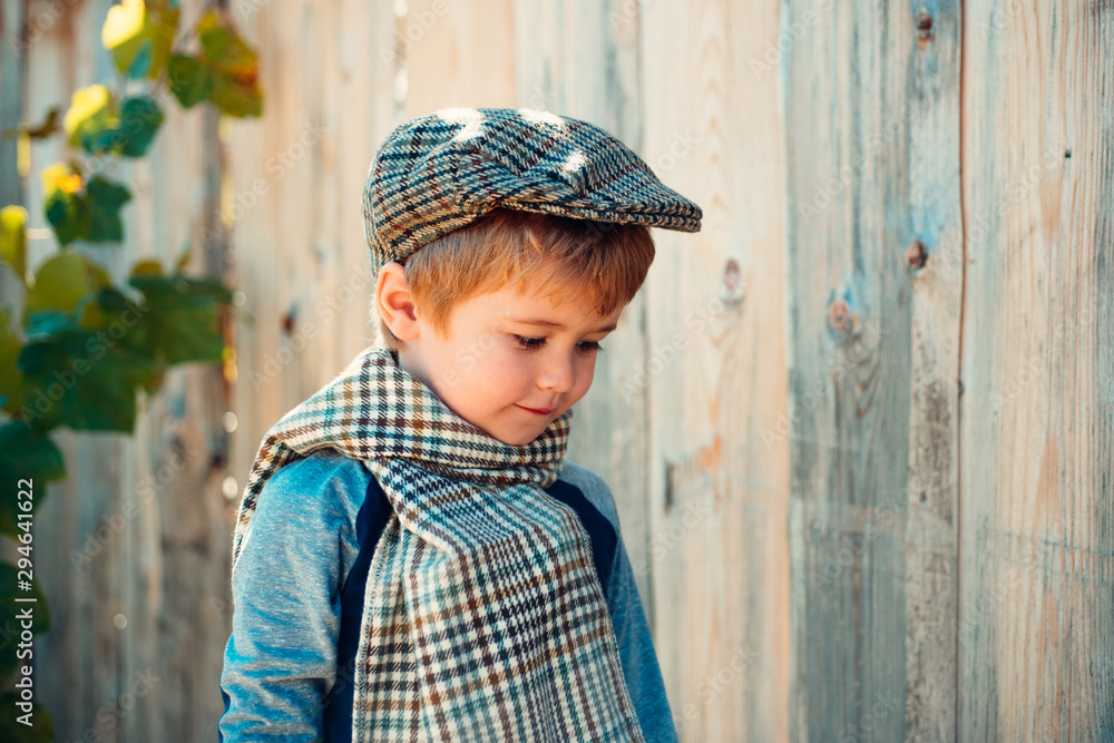 Little boy on a wooden wall background. Humble shy child. Melancholy. Romance. Melancholic mood. Little boy on a wooden wall background. Humble shy child. Melancholy. Romance. Melancholic mood.
