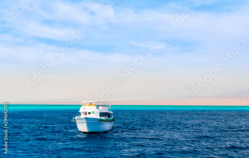landscape tourist boat in the Red Sea on the background of a rocky shore and blue sky and clouds in Egypt in Sharm El Sheikh