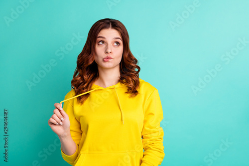 Photo of pensive creative trendy thinking youngster recollecting exam schedule while biting lips looking up in brainstorming isolated over turquoise vivid color background