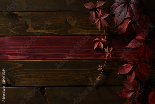 Fotografie Wooden background with red autumn leafs