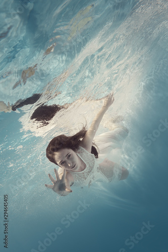 Girl in white swims underwater
