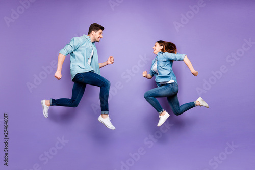 Full body profile side photo of funny funky romantic brunet hair redhair married people jump run after discount feel fun wear modern spring clothes isolated over purple violet color background