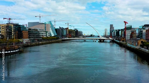 Drone flyignt over the Liffey river in Dublin city showing the Samuel Becket bridge.