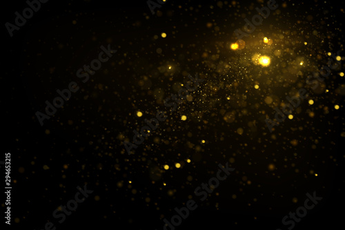 Glowing golden particles on black background