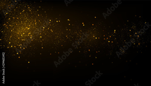 Glowing golden particles on black background