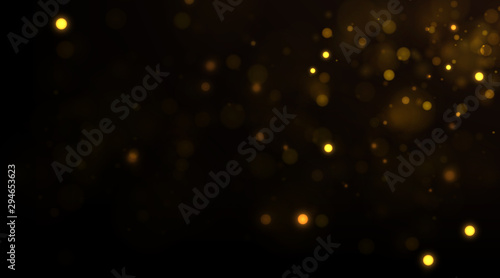 Glowing golden particles on black background