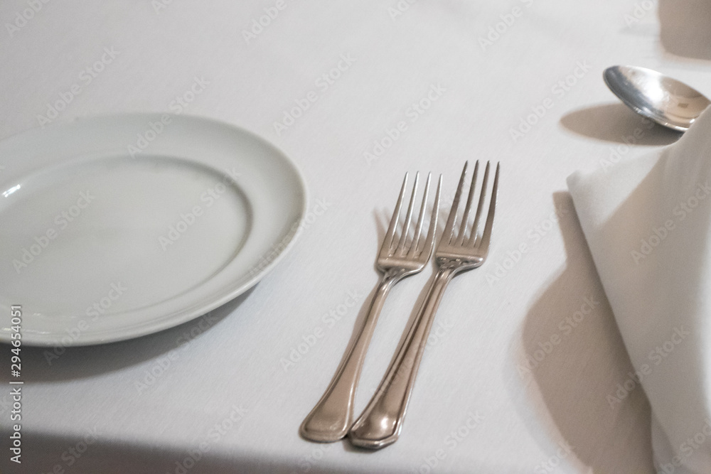garfo e prato em mesa com toalha branca