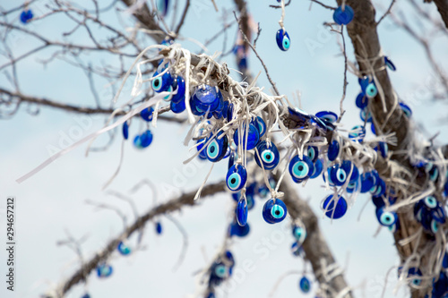 A nazar is an eye-shaped amulet believed to protect against the evil eye. A lot of nazars on the tree. Turkish anti-evil eye amulet photo