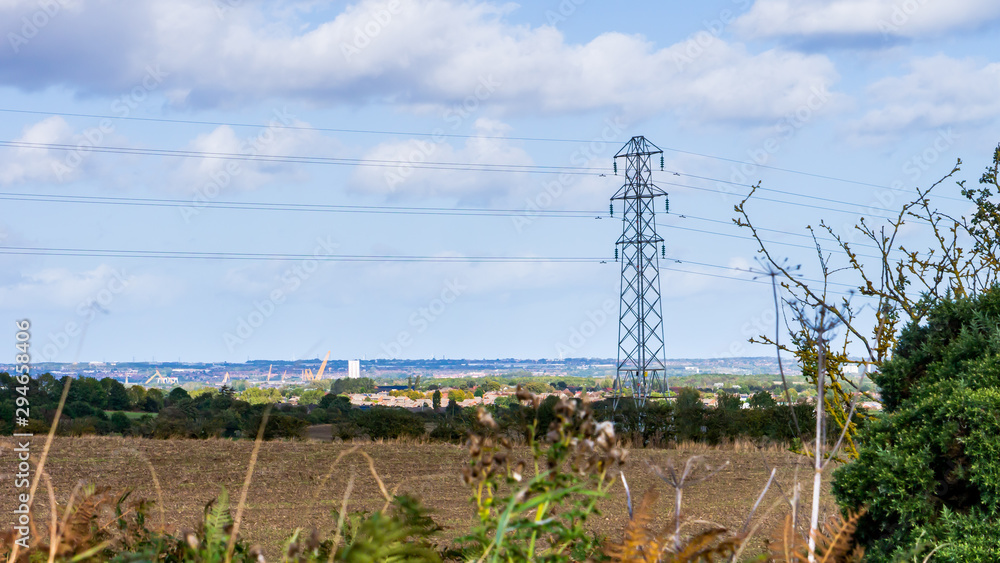 Image of a cultivated field with an electric pylon in the background ...