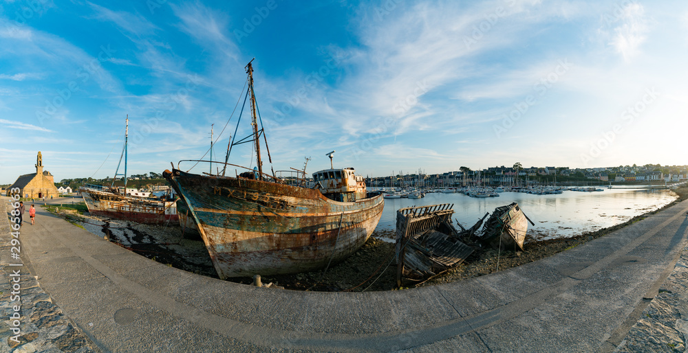 Fototapeta premium tourists visit the historic chapel and fishing boat wrecks in the harbor of Camaret-sur-Mer in Brittany