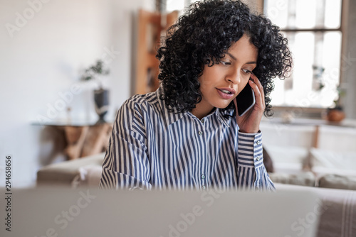 Young female entrepreneur talking with a client on her cellphone photo