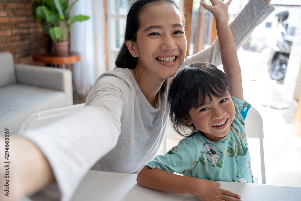 happy asian mother and kid taking selfie together at home happy asian mother and kid taking selfie together at home