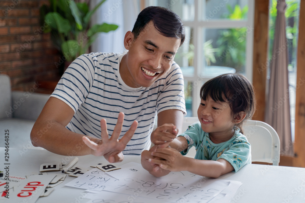 © Odua Images - toddler learning math and counting with her father at home together