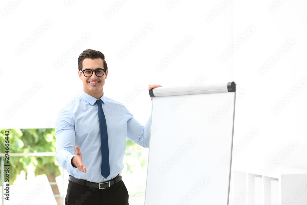 Professional business trainer near flip chart in office Professional business trainer near flip chart in office