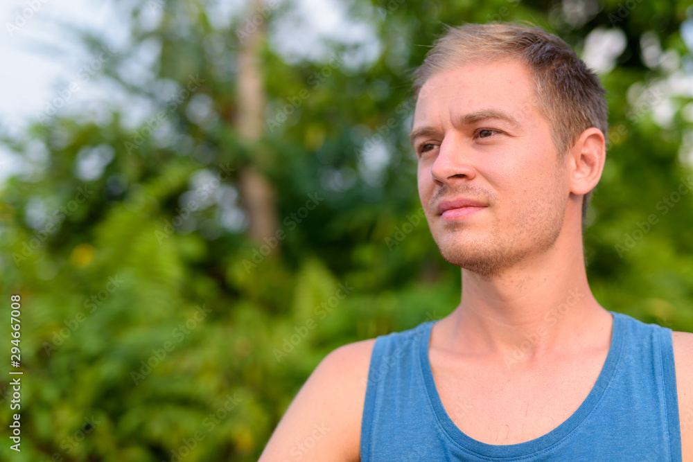 Young handsome man with blond hair relaxing outdoors Young handsome man with blond hair relaxing outdoors