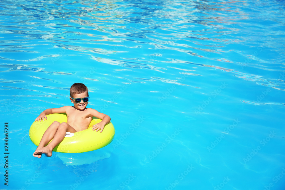 Little boy on inflatable ring in swimming pool