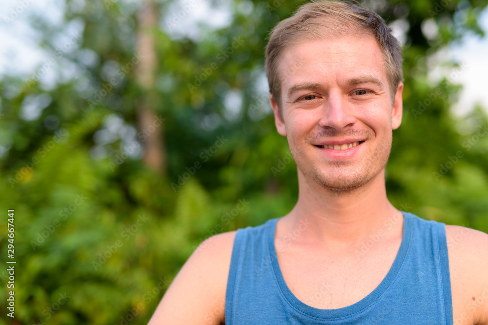 Young handsome man with blond hair relaxing outdoors Young handsome man with blond hair relaxing outdoors