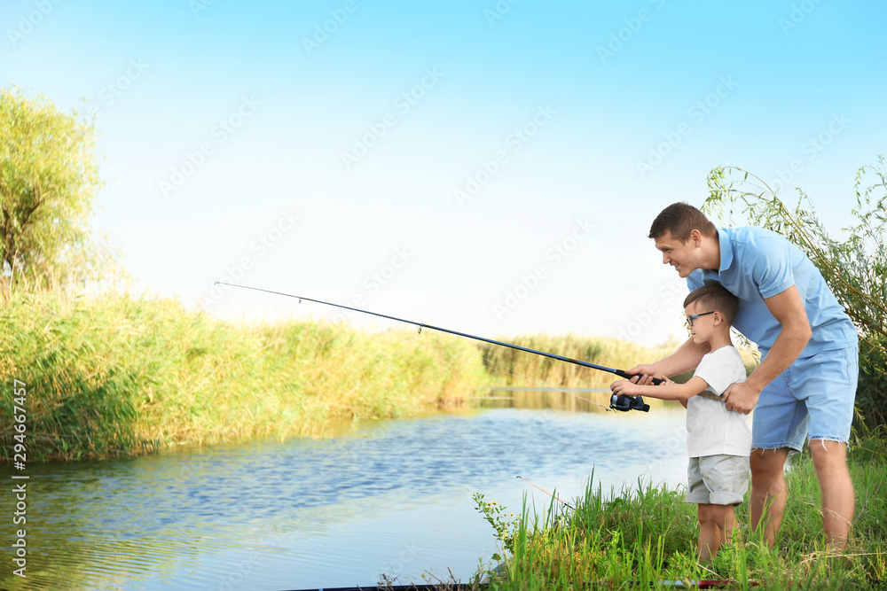 Dad and son fishing together on sunny day Dad and son fishing together on sunny day