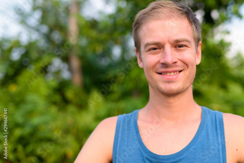 Young handsome man with blond hair relaxing outdoors