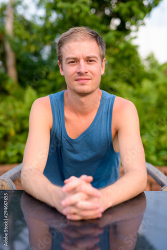 Young handsome man with blond hair relaxing outdoors