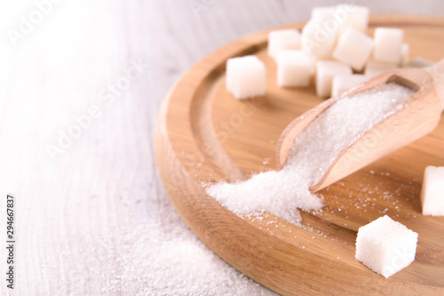 White cane sugar on a light wooden background