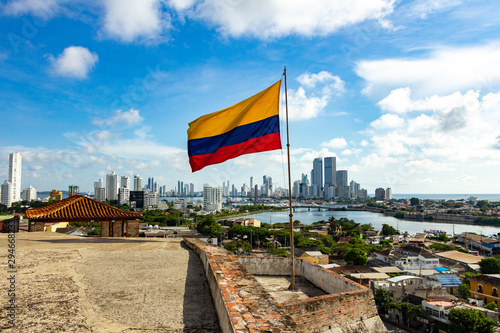 Bandera de Colombia en el Castillo de San Felipe y la ciudad moderna de Cartagena al fondo photo