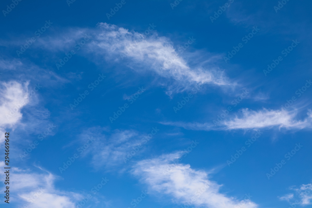 Small, cirrus clouds streaking against a blue sky