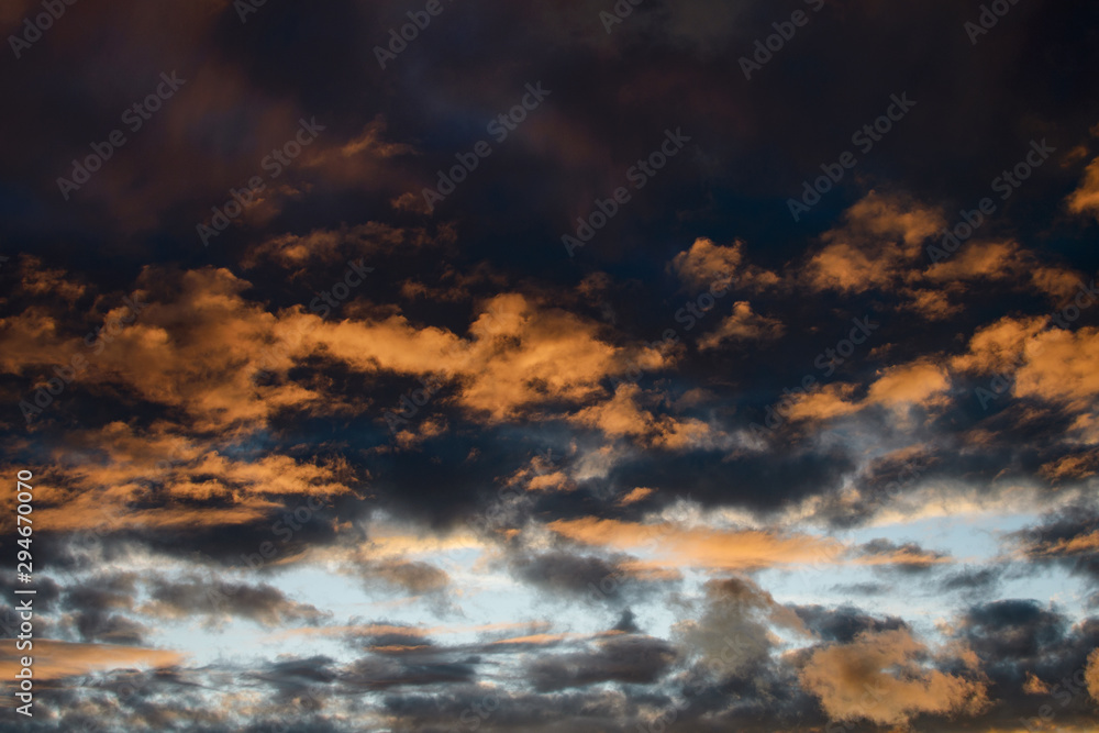 Dramatic sky at sunset or sunrise with red and orange clouds. Variegated colored clouds at the evening sunset of the summer sky. Dramatic sky at sunset or sunrise with red and orange clouds. Variegated colored clouds at the evening sunset of the summer sky.