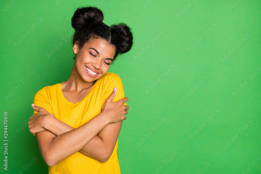 Just me myself and I. Photo of pretty dark skin lady holding herself in close hugs wear casual yellow t-shirt and red pants isolated green background - obrazy, fototapety, plakaty 