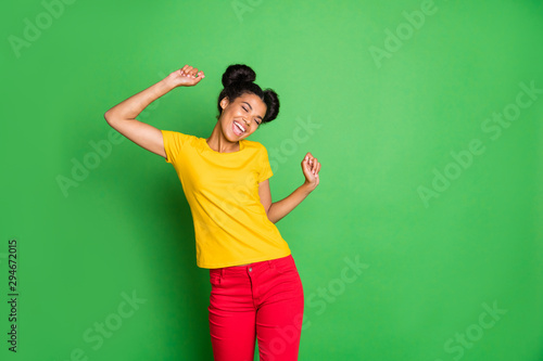 Photo of amazing dark skin lady holding arms raised celebrating summer vacation beginning wear casual yellow t-shirt and red pants isolated green background