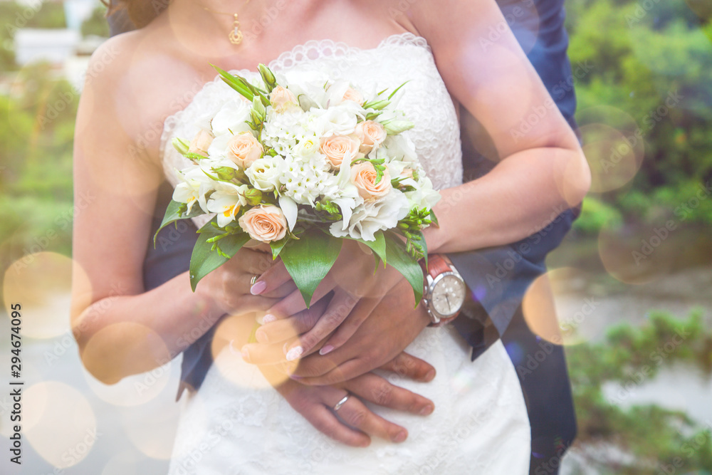 Close-up of newlywed husband embracing wife. Young bride holding wedding bouquet. Happy family life, romance, marriage Close-up of newlywed husband embracing wife. Young bride holding wedding bouquet. Happy family life, romance, marriage