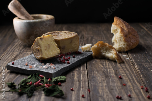 Artesian Cheese and a homemade souer dough bread on wooden background.