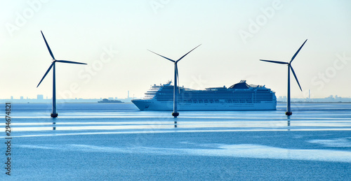 A large cruise ship passes offshore wind turbines near the Oresund Bridge between Denmark and Sweden 