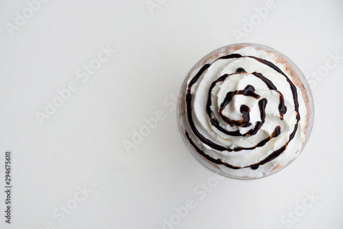 Top view of whipping cream on mocha frappe in plastic cup. Beverage background with copy space.