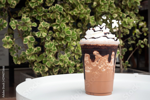 Mocha  frappe in plastic cup with whipping cream and chocolate sauce topping.